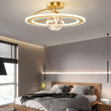 "A gold ceiling light with two rings and a central glass sphere, installed in a bedroom with a wooden bed frame and gray bedding."