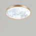 Round flush mount ceiling light with brushed gold metal frame and white textured glass diffuser.