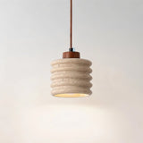 "A travertine pendant light with a ribbed design, isolated on a light background."