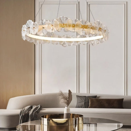 "A circular chandelier with sculpted glass petals and an iron frame in a living area."