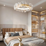 "A circular chandelier with sculpted glass petals and an iron frame in a bedroom."