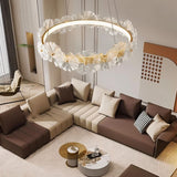 "A circular chandelier with sculpted glass petals and an iron frame in a living room."