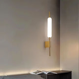 "Modern wall lamp with a cylindrical glass diffuser and iron frame used as a bedside sconce."