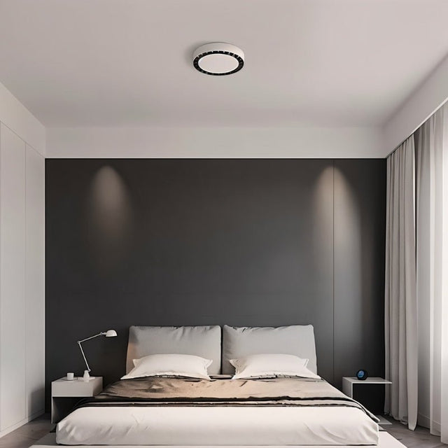 "The Nival ceiling light in a contemporary bedroom, featuring a sleek circular design with intricate accents, made from acrylic and aluminum for efficient and stylish lighting."