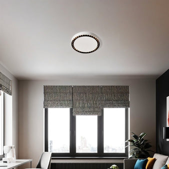 "The Nival ceiling light in a modern living room with white and dark accent details, crafted from durable acrylic and aluminum, enhancing the ambiance with its sleek, circular design."