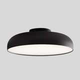 "Close-up view of a sleek Noira ceiling light with a black aluminum and steel finish, featuring a wide, flat design for optimal light diffusion and a minimalist aesthetic."