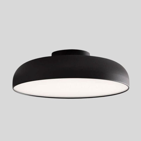 "Close-up view of a sleek Noira ceiling light with a black aluminum and steel finish, featuring a wide, flat design for optimal light diffusion and a minimalist aesthetic."