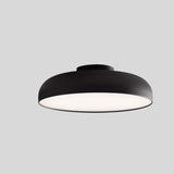 "Minimalist Noira ceiling light fixture in black aluminum and steel, designed with a wide, flat shape to provide even light diffusion and a modern, sleek appearance."