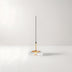 Minimalist pendant light with clear glass dome, brass accents, and black cord against white background.