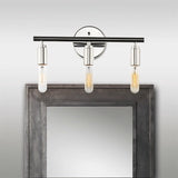 "Chrome 3-light industrial wall sconce with a minimalist design above a mirror."