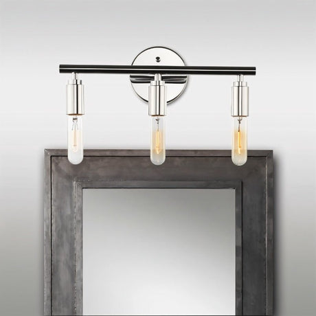 "Chrome 3-light industrial wall sconce with a minimalist design above a mirror."