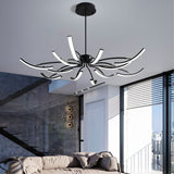 "A black chandelier with twelve curved branches, each tipped with a white light, installed in a modern living room."