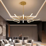 "A gold chandelier with twelve curved branches, each tipped with a white light, installed in a modern living room."