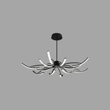 "A wide view of a modern black chandelier with twelve curved branches, each tipped with a white light, against a gray background."