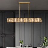 "Linear chandelier with gold frame and textured glass shades over a dining table."