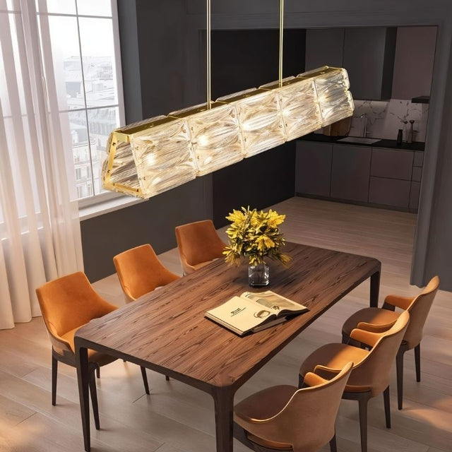 "Modern linear light fixture over a dining table with orange chairs."