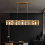 "Modern linear chandelier with gold frame and textured glass shades in a dining setting."