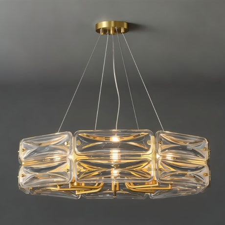 "A modern round chandelier with a geometric glass shade and gold frame, suspended against a gray background."