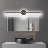 "A modern black wall lamp with a cylindrical bar intersecting a circular base, mounted above a rectangular mirror in a contemporary bathroom with a black vessel sink."