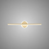 "A modern gold wall lamp with a cylindrical bar intersecting a circular base, showcasing its minimalist design, isolated on a light gray background."
