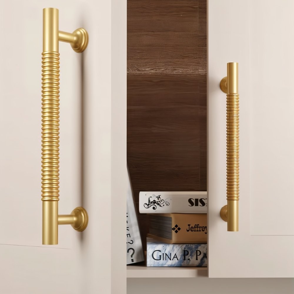 "Solid brass pull bar handles with a grooved design on a built-in bookshelf with decorative books."