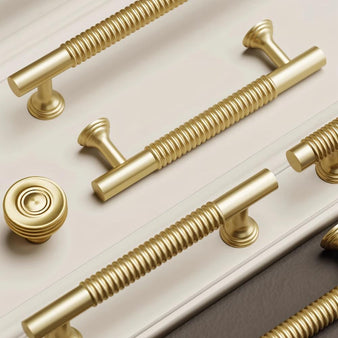 "Close-up of solid brass knobs and pull bars with a grooved design, showcasing their refined, industrial look."