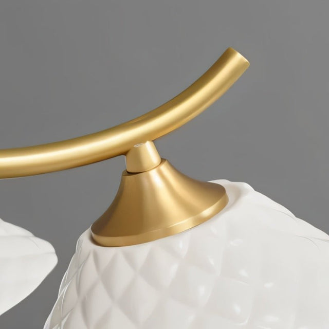 "Close-up of a modern chandelier's brass arm and ceramic shade detail."