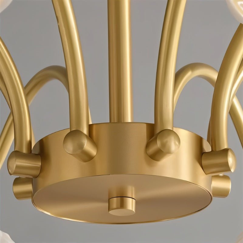 "Close-up of a modern chandelier's brass center with curved arms."