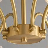 "Close-up of a modern chandelier's brass center with curved arms."