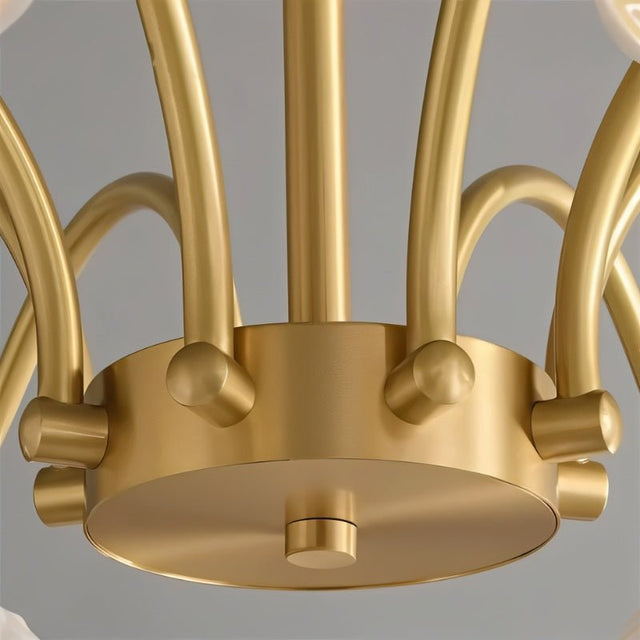 "Close-up of a modern chandelier's brass center with curved arms."