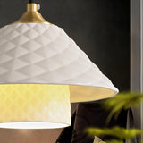 "Close-up of a modern pendant light with a textured ceramic shade and warm light."