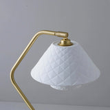 Detail view of Ocris Table Lamp's white quilted ceramic shade and brass fixture, highlighting elegant indoor lighting design.