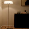 "Modern floor lamp with a ring-shaped fabric shade and slim tripod base, providing soft, diffused lighting."