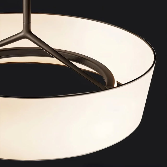 "A close-up view of a pendant light showing the texture of the wide, white fabric drum shade and the sleek frame."