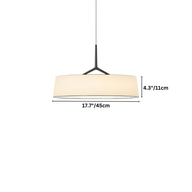"A minimalist pendant light with a wide, white fabric drum shade and a sleek frame hangs suspended."