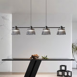 "Modern linear chandelier with ribbed glass shades and a black iron frame illuminating a contemporary dining room."
