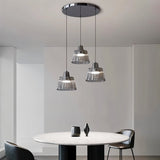"Modern chandelier with ribbed glass shades and a black iron frame illuminating a contemporary dining room."