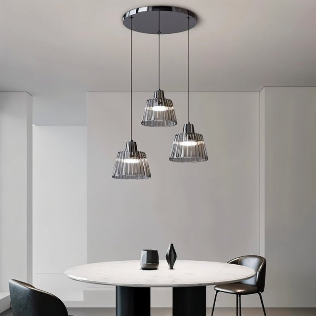 "Modern chandelier with ribbed glass shades and a black iron frame illuminating a contemporary dining room."