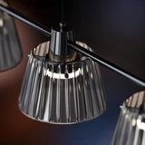 "Close-up of a ribbed glass shade on a modern chandelier, showing its texture and design details."