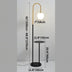 Black floor lamp with brass arch and globe light fixture, featuring integrated side table, shown with dimensions.
