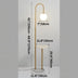 Brass arc floor lamp with white globe and marble side table against neutral background.