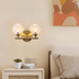 Brass dual globe wall sconce with clear rippled glass shades, modern mid-century style