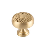 "A gold brass geometric knob with a lattice and sunburst design, front view on a white background."