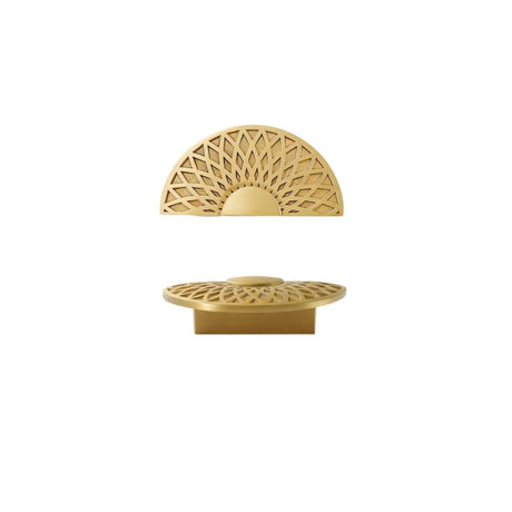 "A gold brass geometric knob with a lattice and sunburst design, isolated on a white background."