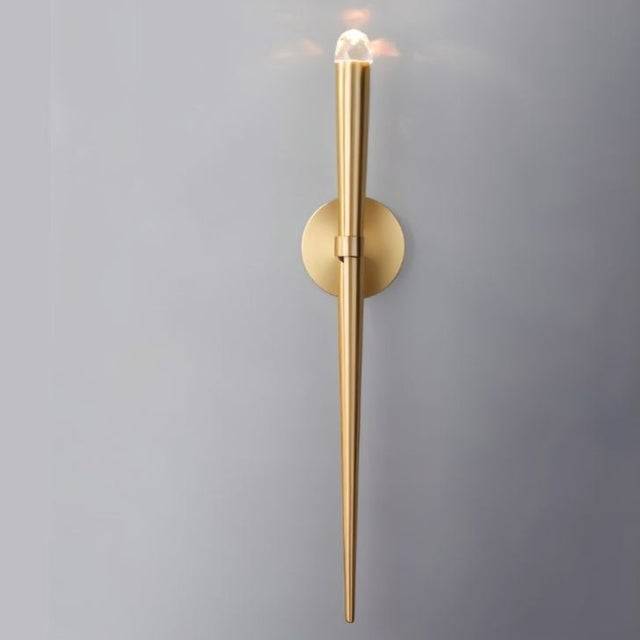 "Modern wall lamp with a tapered gold finish and crystal accent, providing soft, ambient lighting."