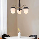 "A 3-light chandelier with brass arms, wooden centerpiece, and frosted glass shades over a dining table."