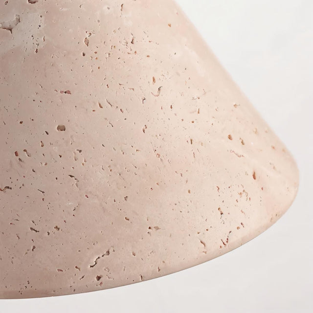 "Close-up detail of a modern wall lamp with a conical travertine shade, showcasing the natural texture and pattern of the stone."