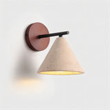 "A modern wall lamp with a conical travertine shade and a black arm, mounted on a round wooden backplate."