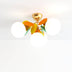 Colorful ceiling chandelier with gold finish, white frosted glass globes, and orange and yellow decorative leaves.