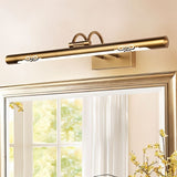 "A close-up of a copper LED vanity light with decorative cutouts above a framed mirror."
